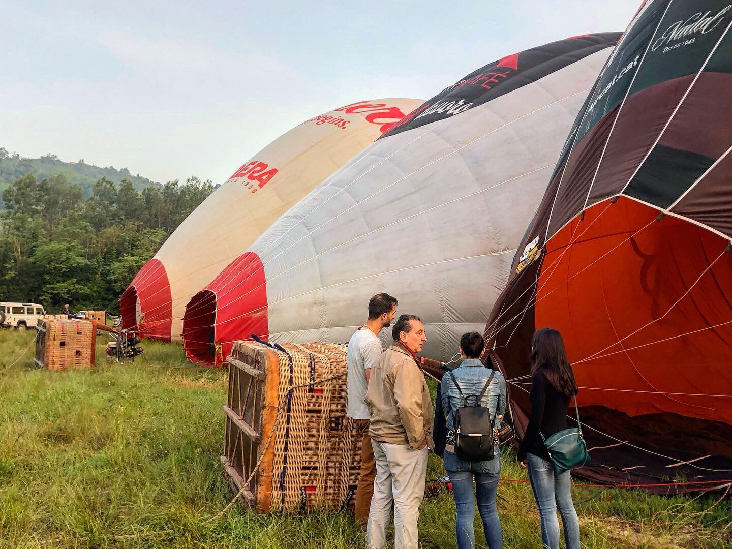 a group of people standing on top of a grass covered field